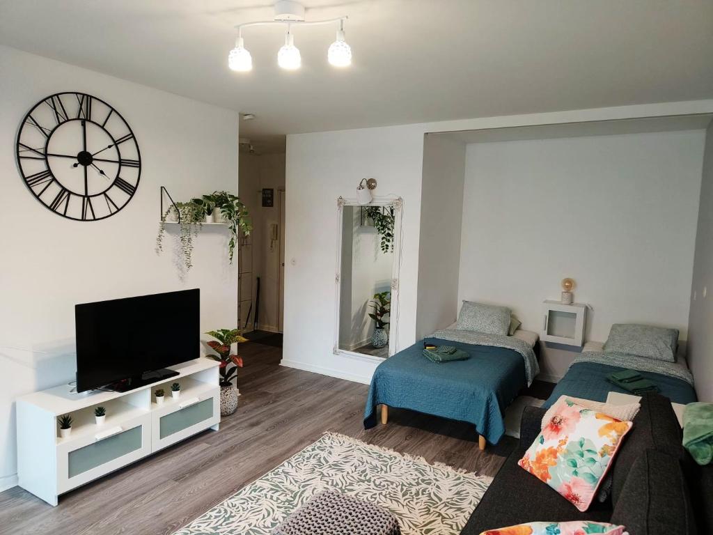 坦佩雷City Apartment的带沙发、电视和时钟的客厅