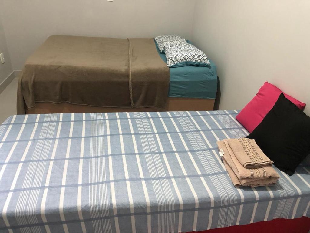 帕尔马斯Residencial Jasmim的两张睡床彼此相邻,位于一个房间里