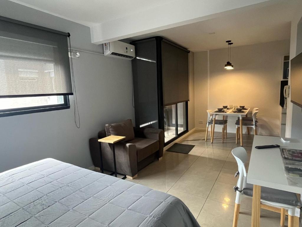 罗萨里奥Premium Apartment Rosario - Joan Miró的一间卧室配有一张床,客厅配有桌子