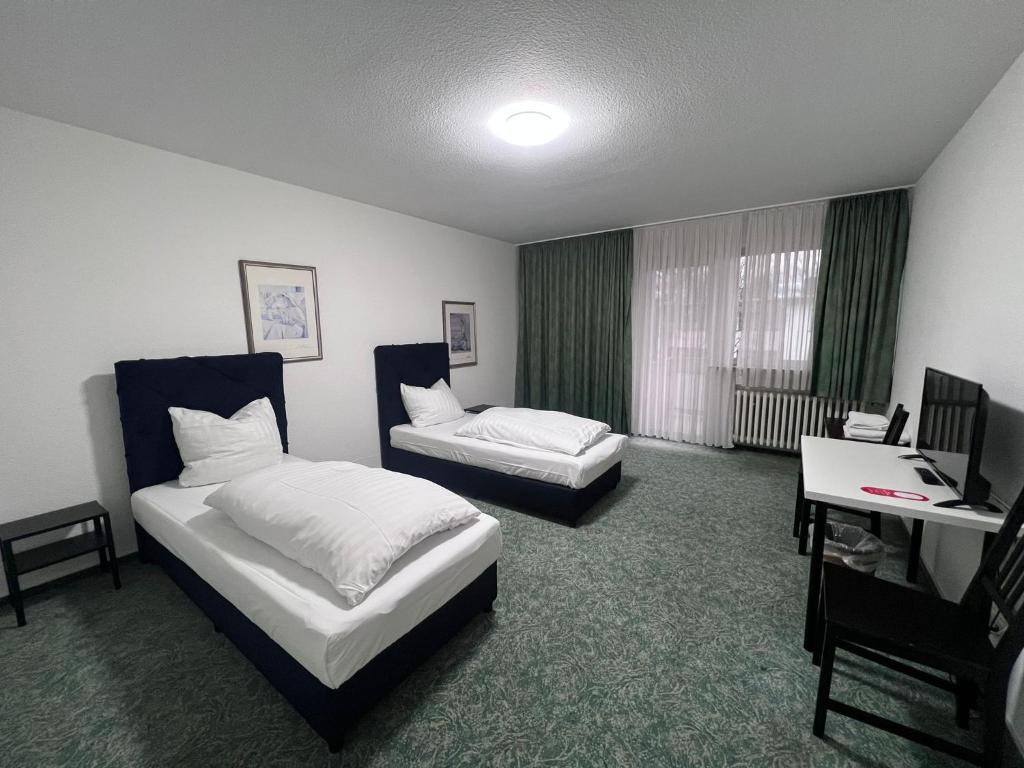 勒沃库森Haven - Hotel Am Stadion的酒店客房配有两张床和一张书桌