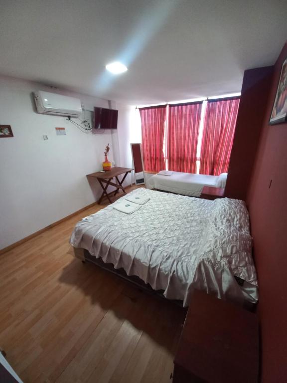 圣萨尔瓦多德朱Hotel Ery Noa的一间卧室配有床和红色窗帘的窗户