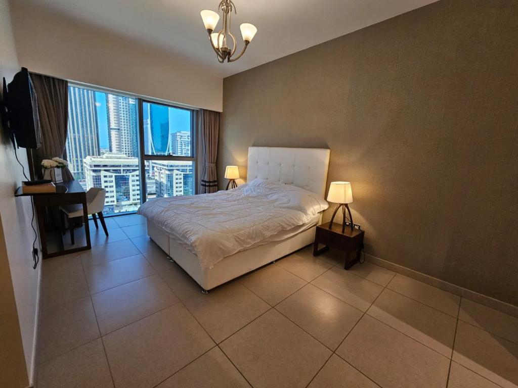 迪拜2 bedrooms flat in Central Park Tower, Dubai, DIFC的一间卧室设有一张大床和一个大窗户