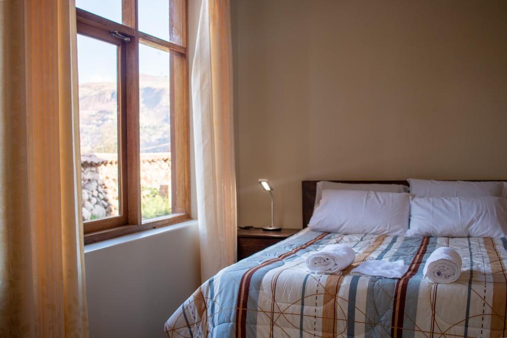 乌鲁班巴Allin Illary Eco Hospedaje的一间卧室配有一张带窗户的床