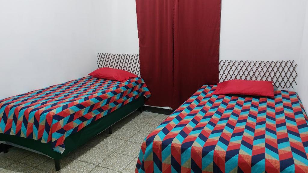 圣何塞港Casa de descanso Grace的两张睡床彼此相邻,位于一个房间里