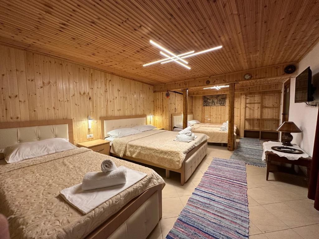 吉诺卡斯特"Mani Guest House"的一间卧室设有两张床和木制天花板