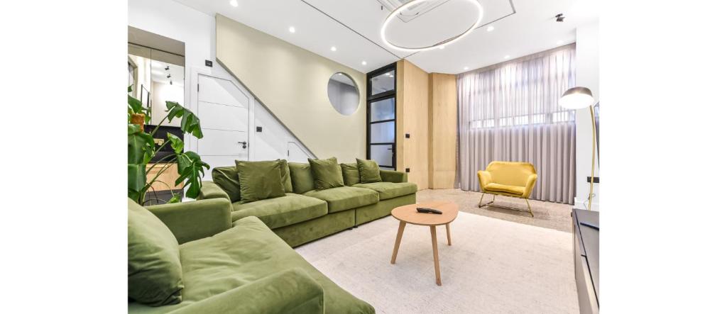 伦敦Luxury Abode: 5-Bed Haven Ideal for Big Groups!的客厅配有绿色沙发和桌子