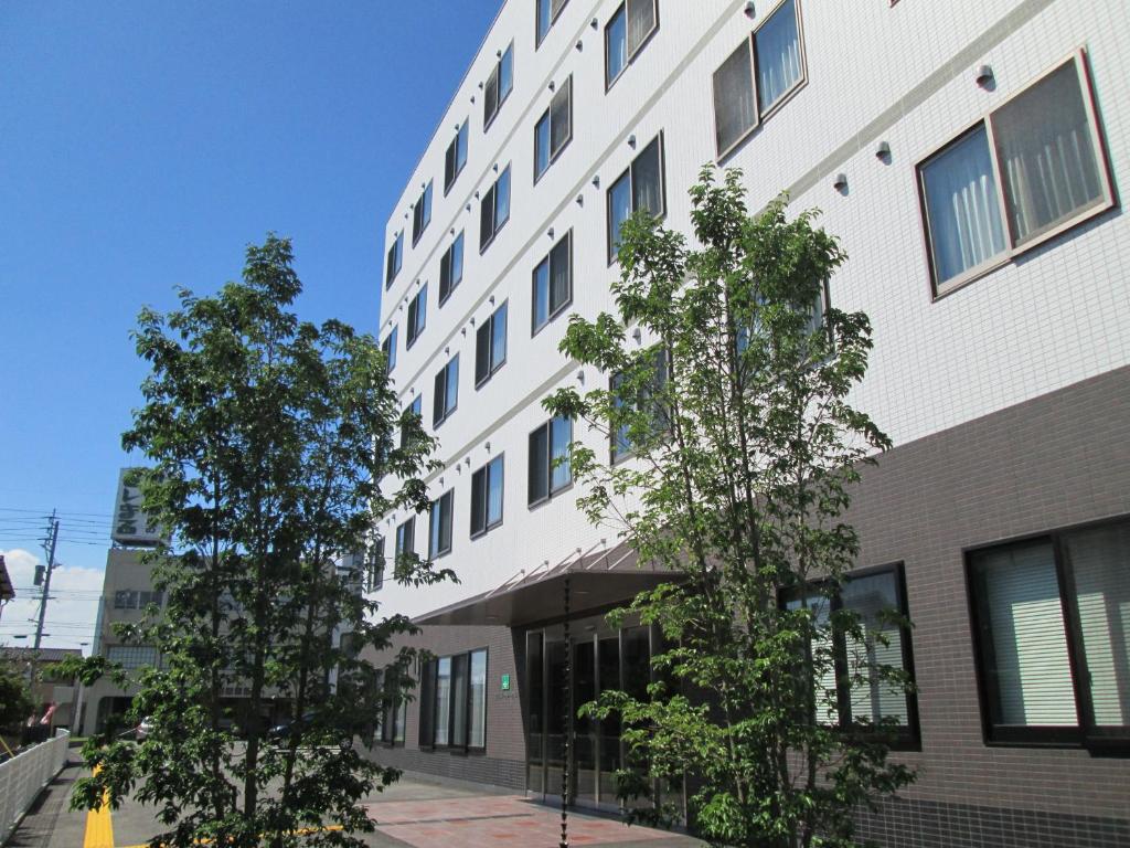 大川大川河畔酒店 的前面有树木的白色建筑