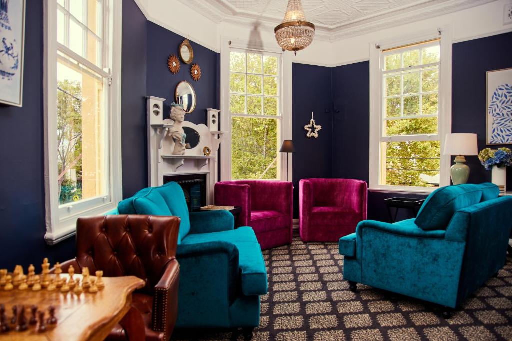 悉尼The Australian Heritage Hotel的客厅设有蓝色的墙壁和色彩缤纷的椅子