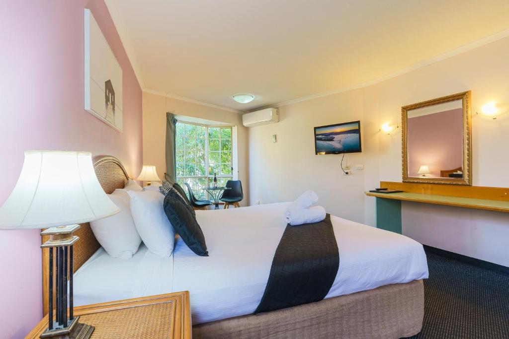 梅林布拉蓝宝石沃特斯汽车旅馆的酒店客房,配有床和镜子