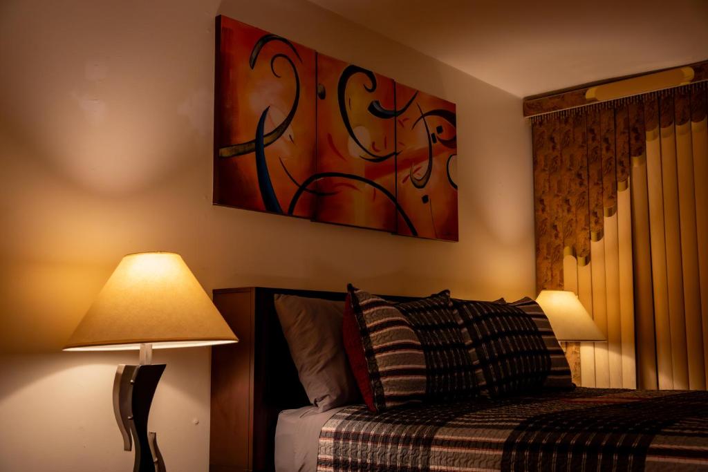 布鲁克林Spacious Comfy Room in Cozy Classy Duplex的卧室配有一张床,墙上挂有绘画作品