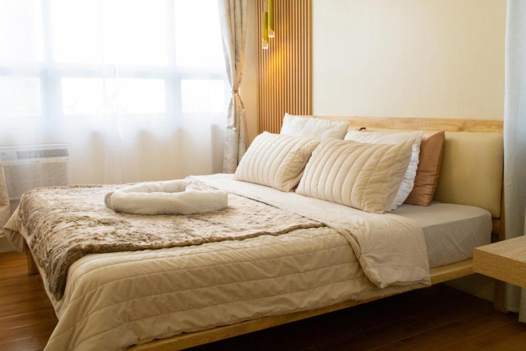 达沃市Micairan Suite的卧室配有带白色枕头的床和窗户。