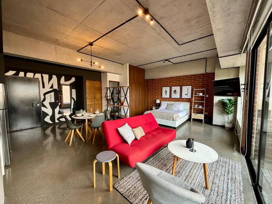 危地马拉Artistic Apartment in Zone 4的客厅配有红色的沙发和桌子