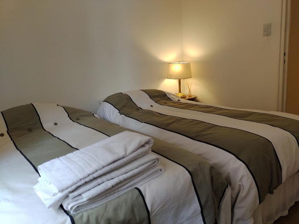 科尔多瓦Depa 900 cómodo remodelado centro cerca de todo的客房内的两张床和毛巾