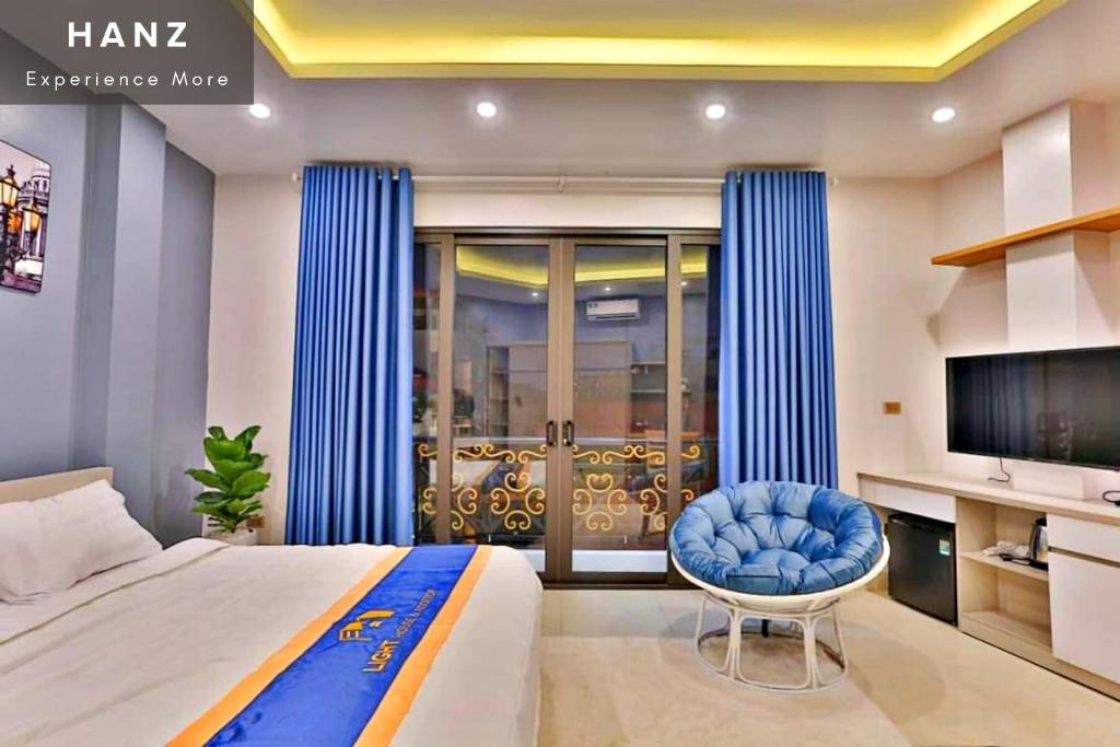 河内HANZ Light House Hotel & Apartment的一间卧室配有一张床、一把椅子和电视