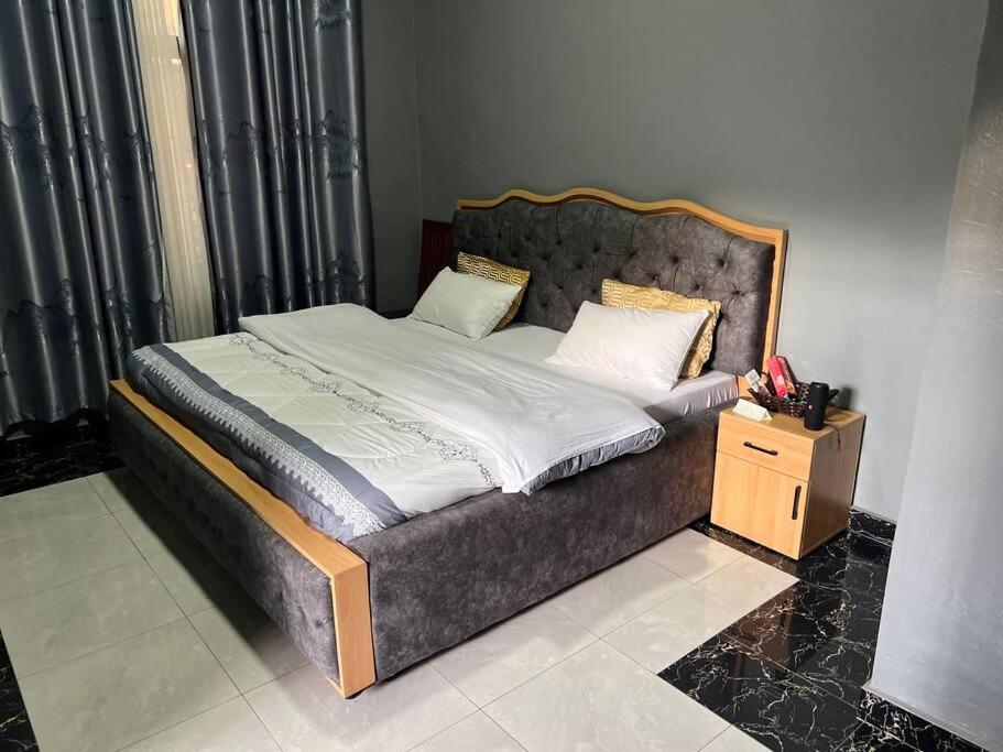鲁亨盖里2 bedroom apartment in Musanze( Benji)的一间卧室配有一张木架大床
