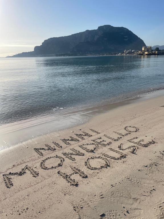 蒙德罗Ninni Mondello House的海滩上沙子上写的消息