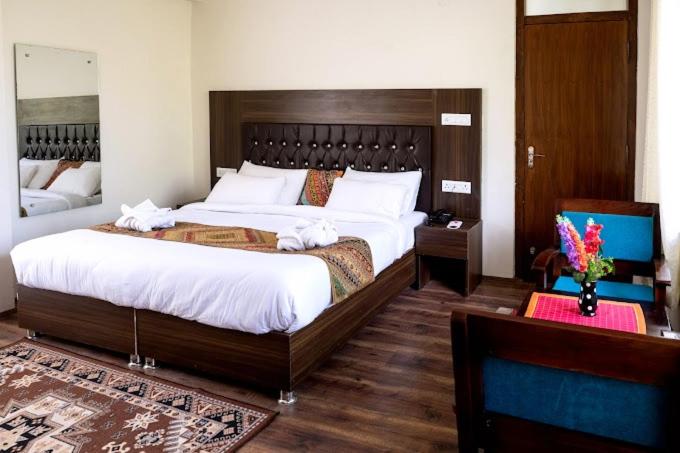 列城Hotel Wangchen的一间卧室配有一张大床和木制床头板