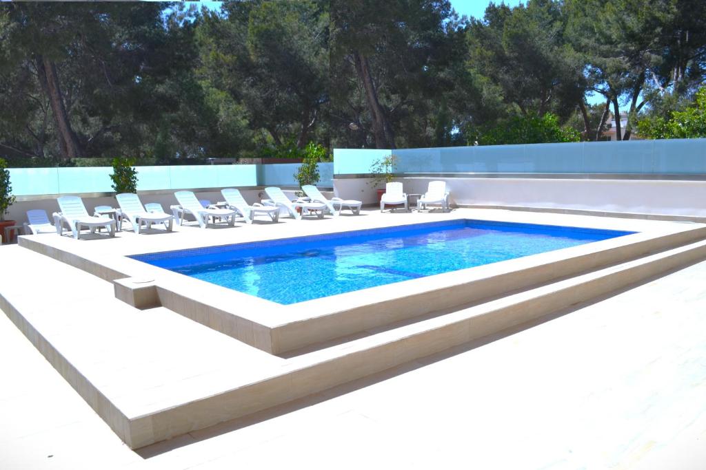 埃尔阿雷纳尔菲尼克斯酒店的一个带躺椅的游泳池和一个游泳池