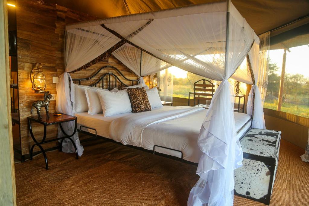 OlolaimutiekExplore Nature Lodge的一间卧室配有一张带天蓬的大床