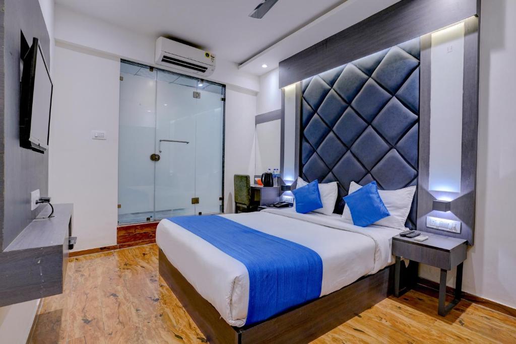 孟买Hotel Gorrion的一间卧室配有一张带蓝色枕头的大床