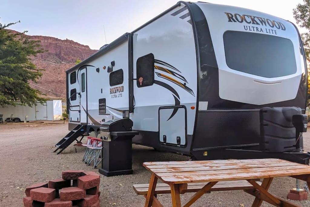 摩押Moab RV Resort Glamping RV Setup OK33的野餐桌旁的白色转轮