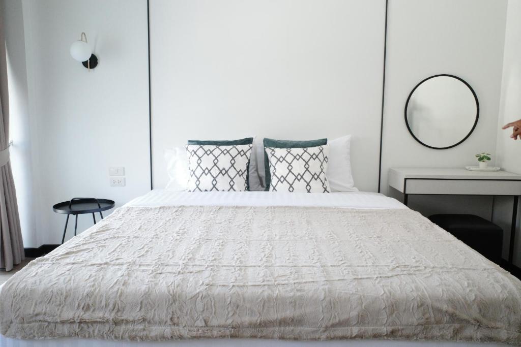 Ban PhalaVIYA Residence的卧室配有一张带镜子的白色大床