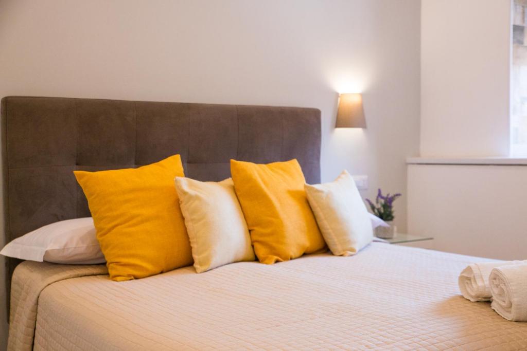 索伦托索伦托里沃利酒店的一张黄色和白色枕头的床