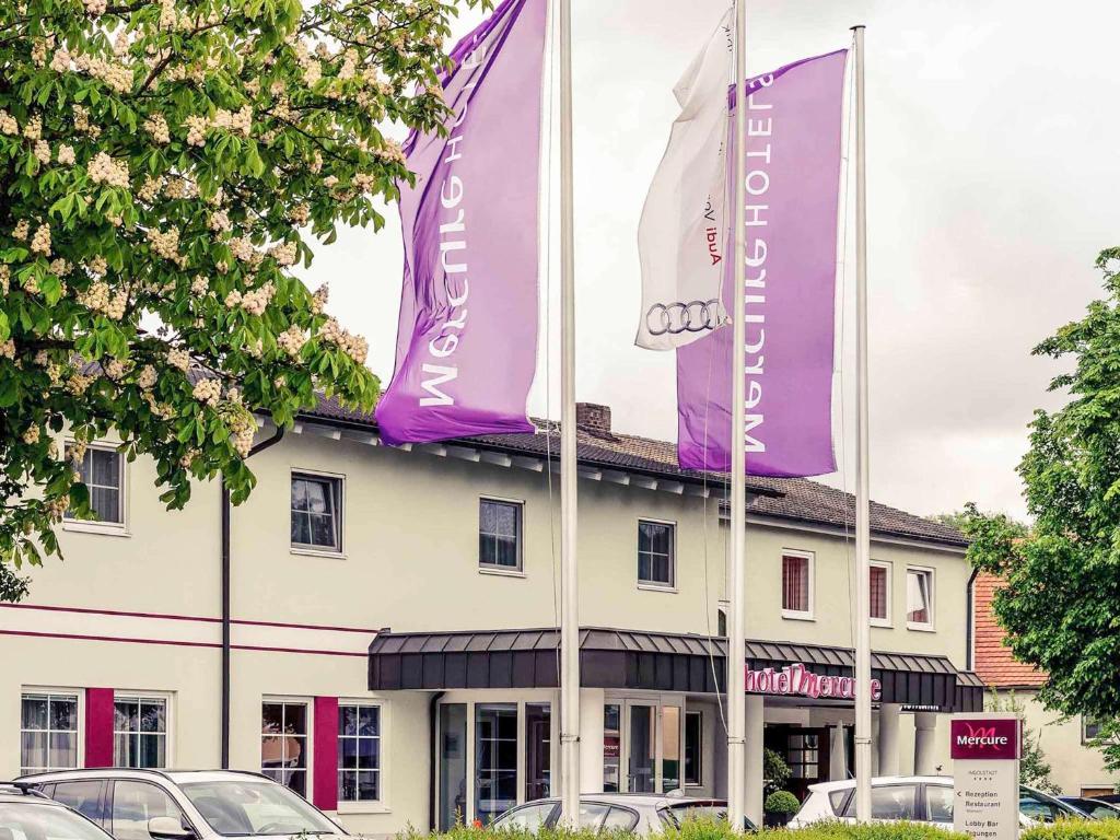 因戈尔施塔特美居因戈尔施塔特酒店的前面有紫色和白色旗帜的建筑