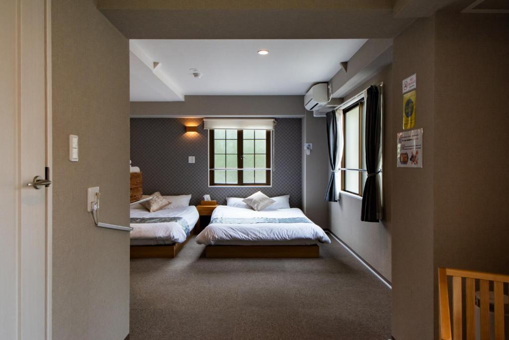 奈良Hotel Neiraku的一间卧室设有两张床和窗户。