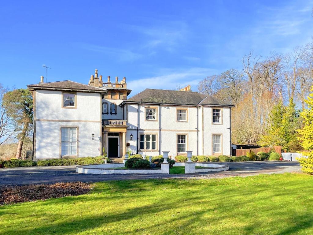 ArnistonThe Mansion House At Kirkhill的一座带绿色草坪的大型白色房屋
