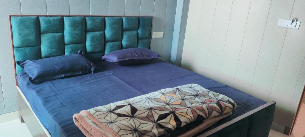 BasāriShri Ji Palace的一张带蓝色床单和枕头的床