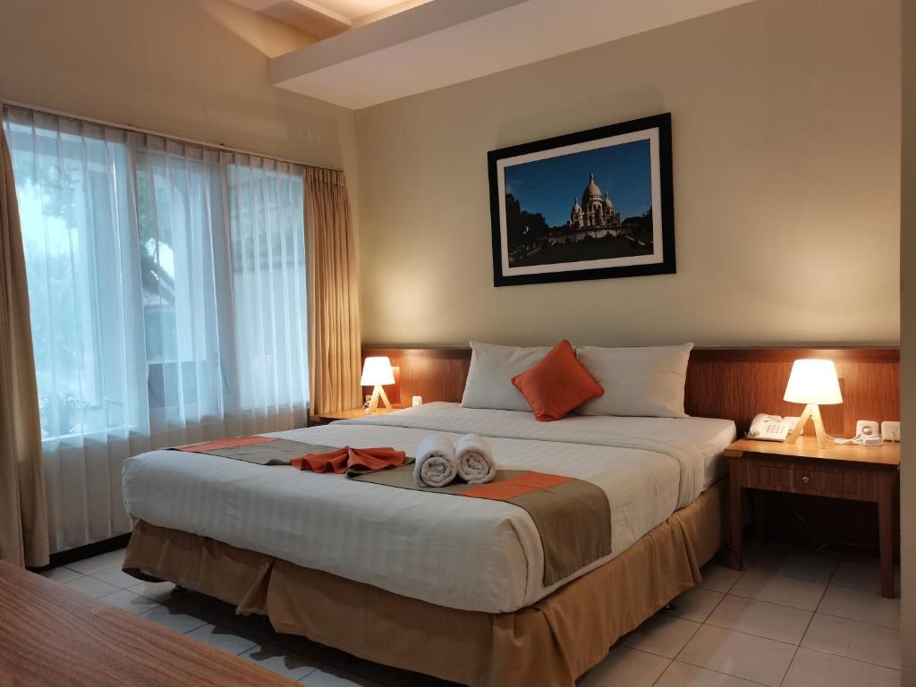 马格朗Hotel Catur Putra的一间卧室配有一张大床和两条毛巾