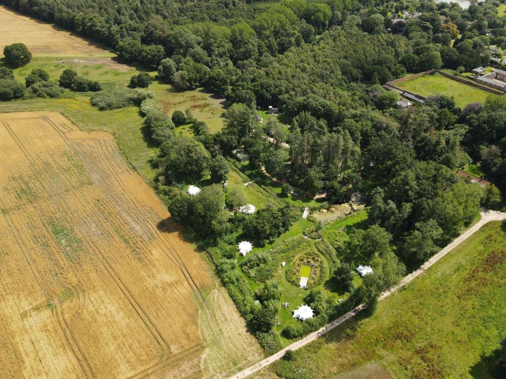 诺里奇Moat Island Glamping的享有农场的空中景色,拥有田野和树木