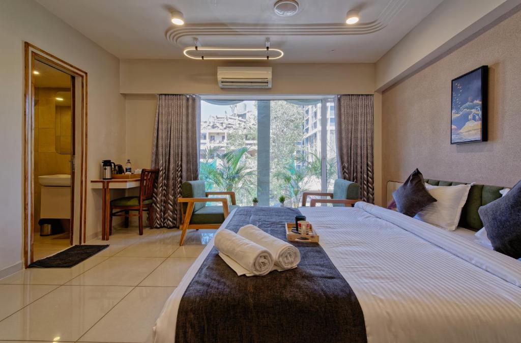 艾哈迈达巴德Exora Inn的酒店客房带一张大床,带毛巾
