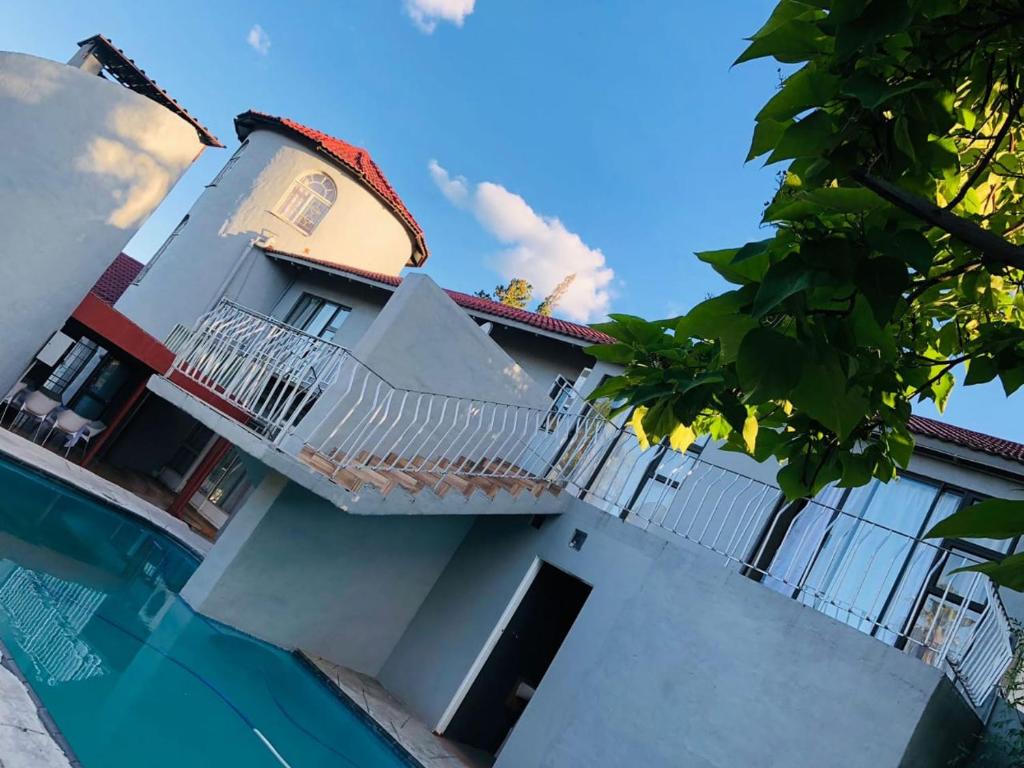 布隆方丹Eeufees Guesthouse的带阳台和游泳池的度假屋