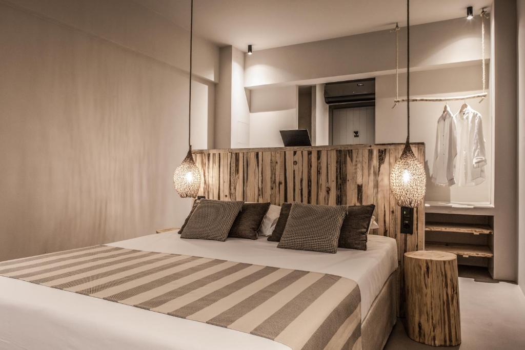 毕达哥利翁Doryssa Boutique Hotel的一间卧室配有一张带两个灯的床