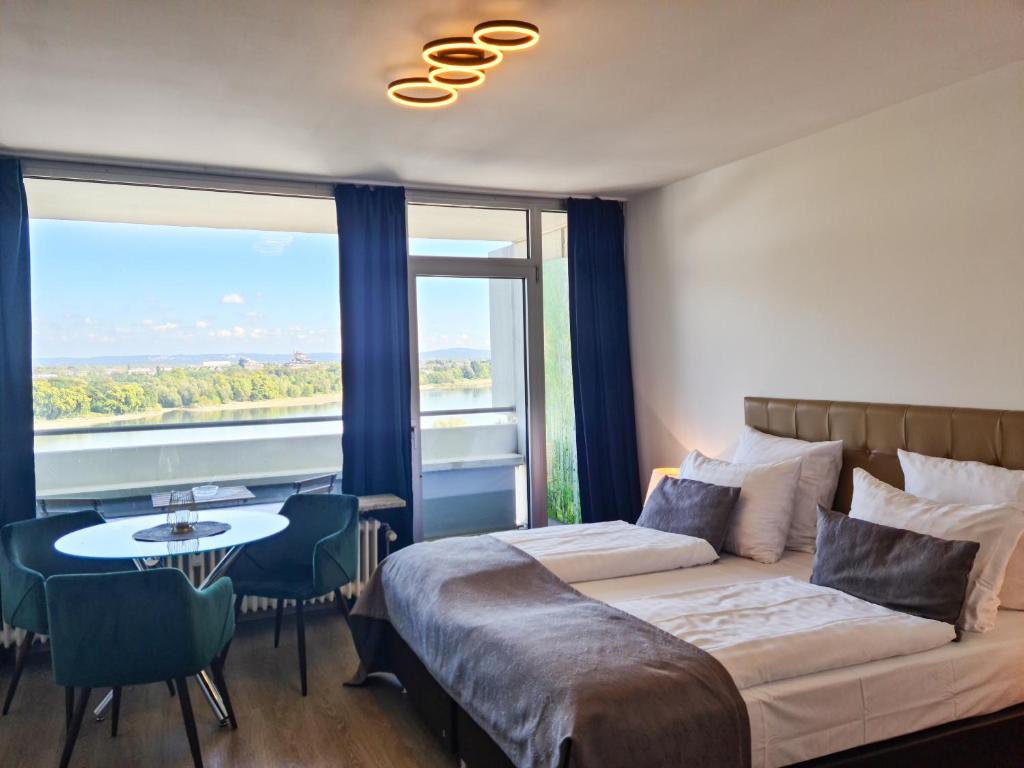 科隆Rheinblick Apartments的一间卧室配有一张床、一张桌子和一个窗户。