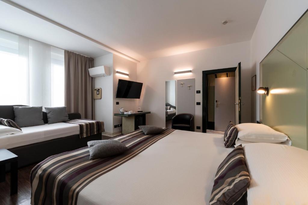 特伦托布里科斯里昂酒店的一间酒店客房,设有两张床和电视