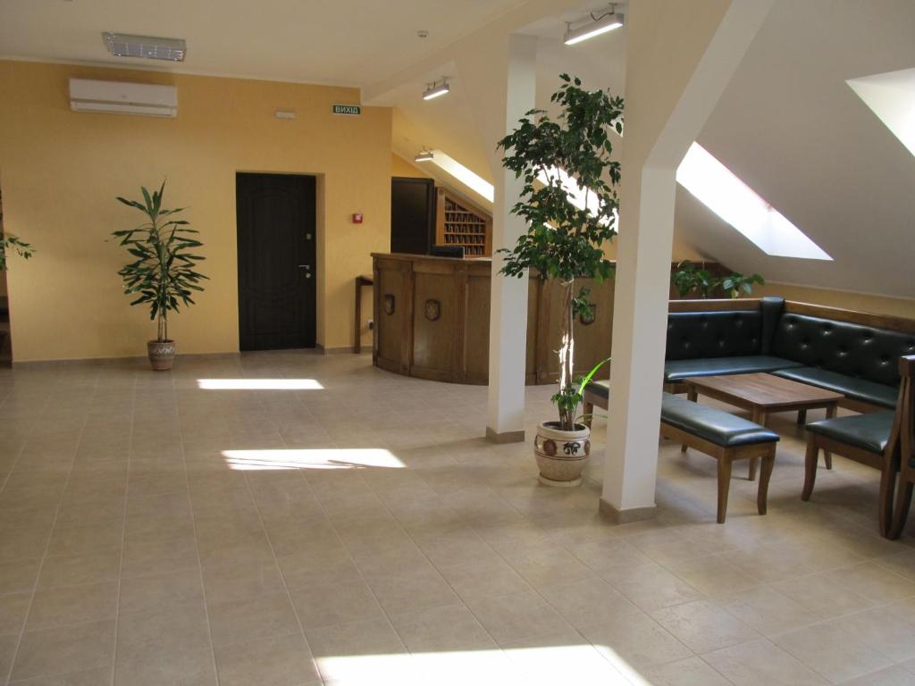 乌日霍罗德Mini-hotel Na Pidgradskiy的大堂配有沙发、桌子和植物