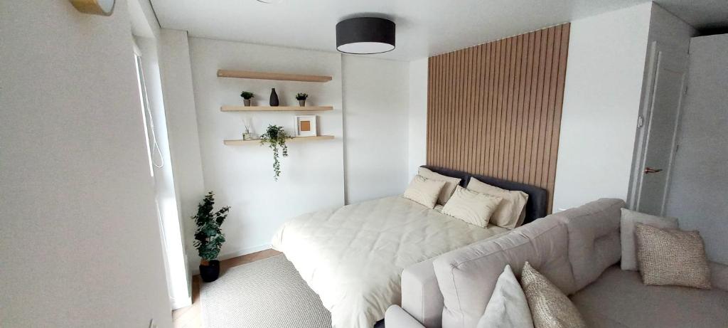 考纳斯Hygge Apartment in Silainiai, Kaunas的卧室配有白色的床和沙发