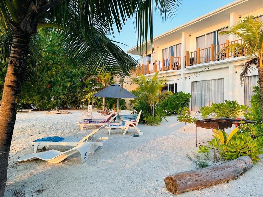 迪弗西The Sunset Villa的一个带椅子和遮阳伞的海滩和一家酒店