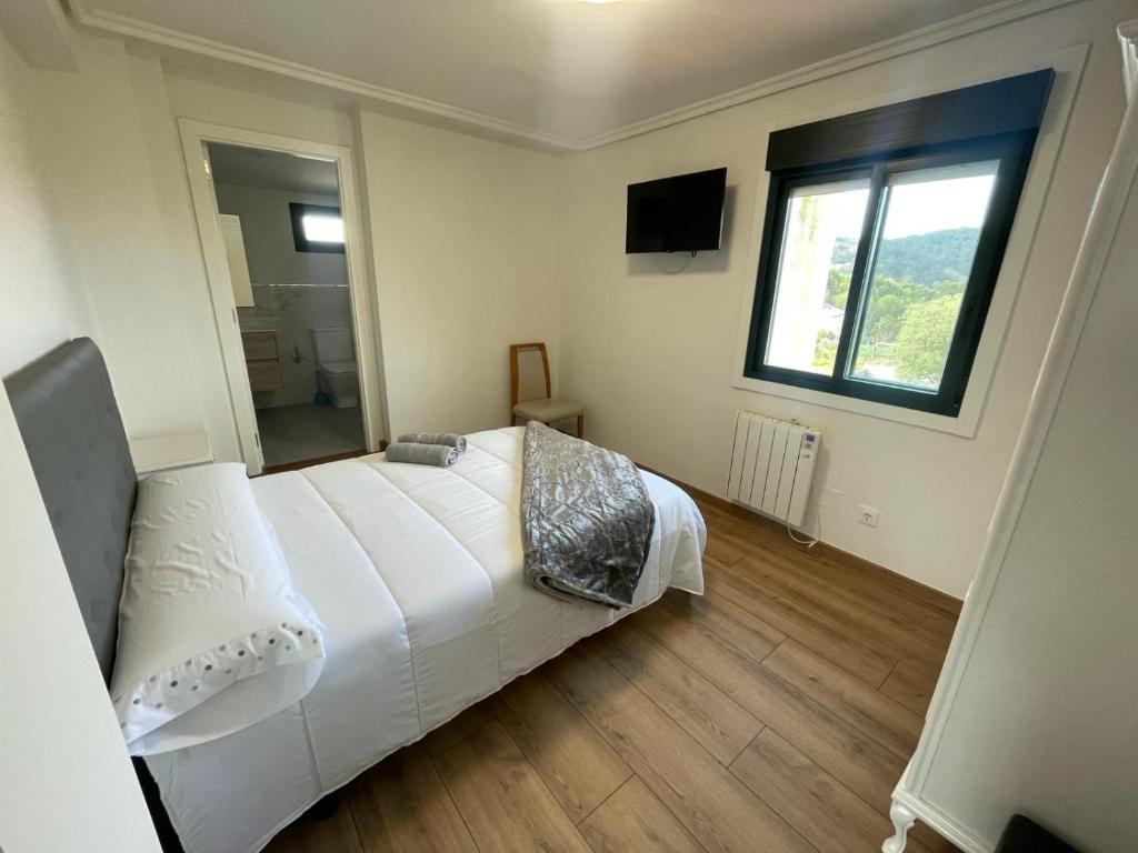 维戈Posada Celtia的卧室设有一张白色大床和一扇窗户。