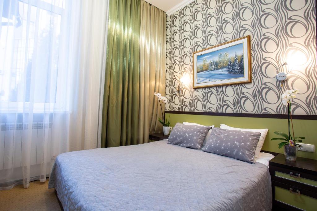 哈尔科夫Hotel Voyage的卧室配有一张床,墙上挂着一幅画