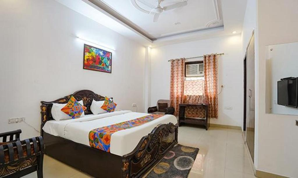 诺伊达FabHotel Noida Sector 50的一间卧室配有一张床和一台电视