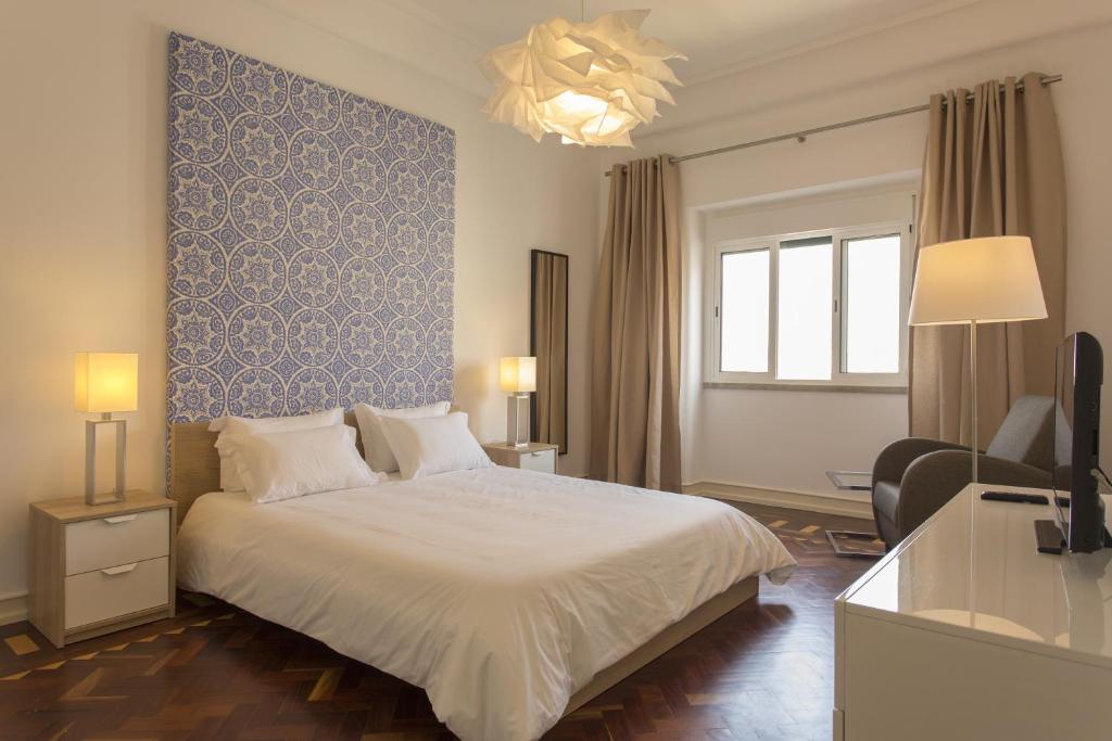 里斯本加斯帕之家旅馆的一间卧室设有一张床和蓝色的墙壁