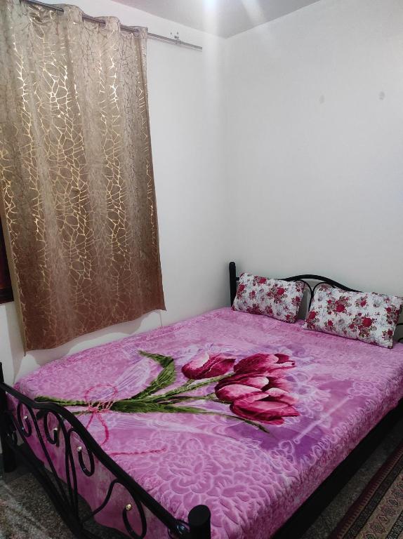 马拉喀什Appartement situé à 5 minutes à pied de l'Aeroport de Marrakech的一间卧室配有一张粉红色的床,上面有玫瑰花