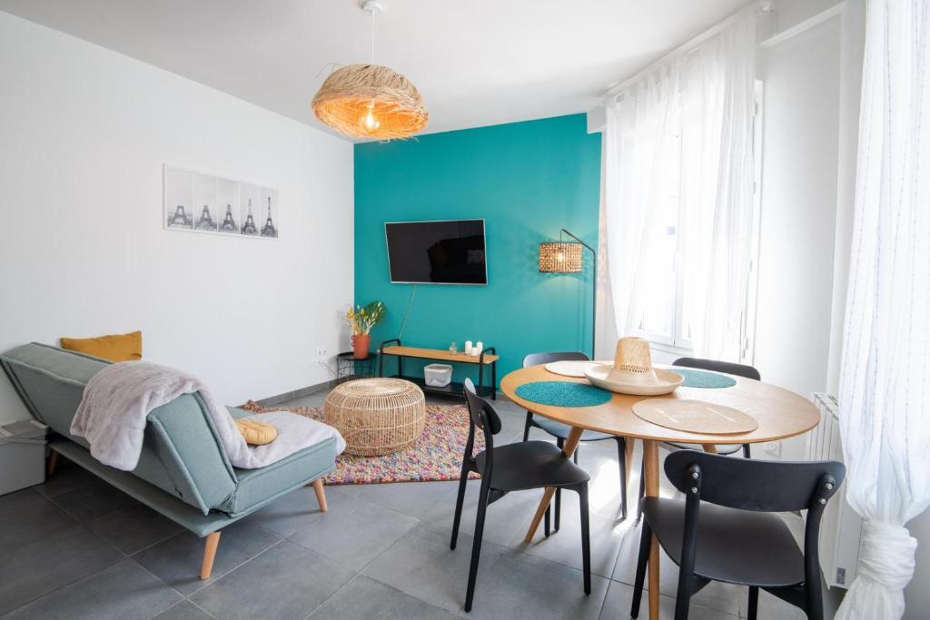 图尔Comfort and modernity in a townhouse的客厅配有桌子和蓝色的墙壁