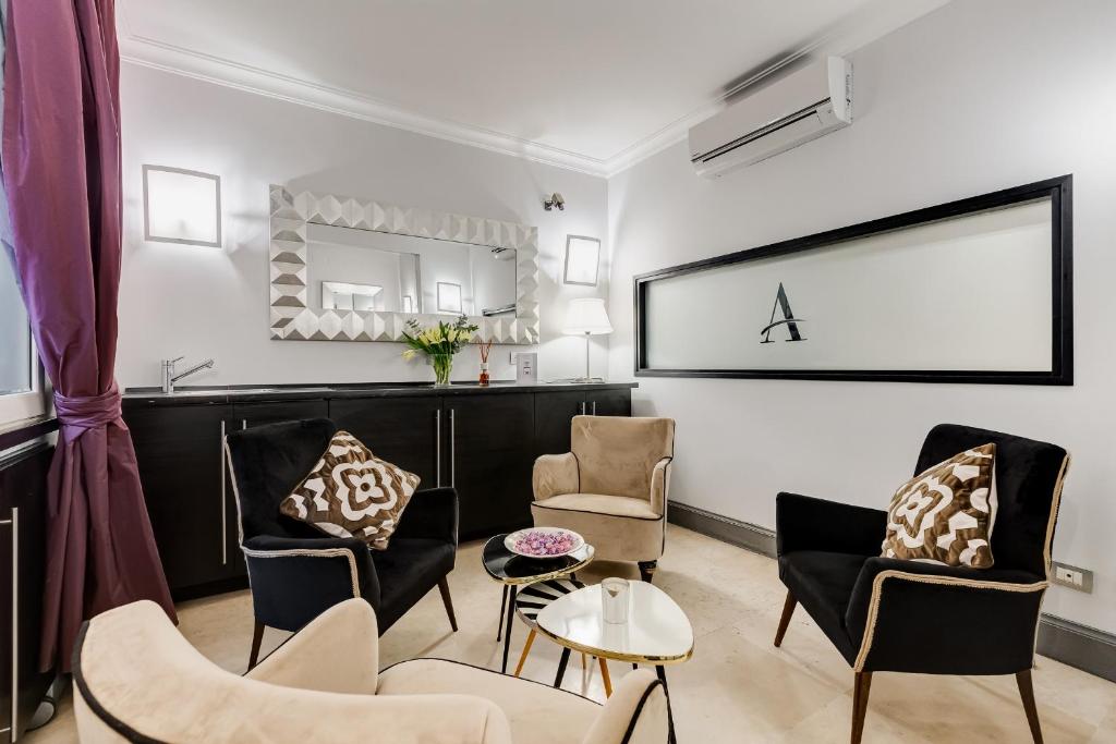 罗马Residenza A -Via Veneto Fashion Rooms -self check-in的客厅配有椅子和桌子