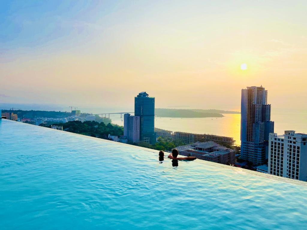 西哈努克AIR APARTMENTS Residence - Sihanoukville - 400m to boat pier的一座城市建筑屋顶上的无边游泳池