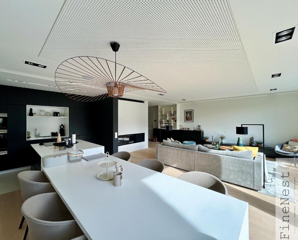 斯帕Appartement 3 chambres "Luxury Nest Spa F1" by FineNest的客厅配有一张白色的大桌子和椅子